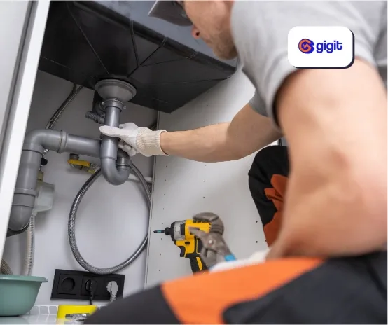 Plumber fixing a pipe under the sink